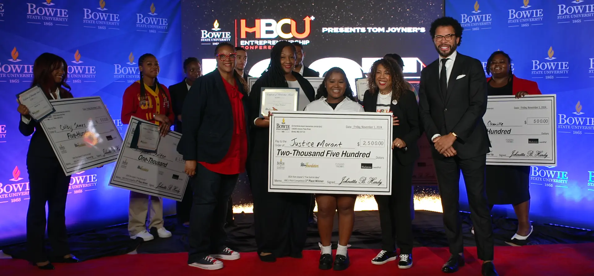 Winners of the HBCU+ Entrepreneurship Conference pitch competition holding oversized prize checks