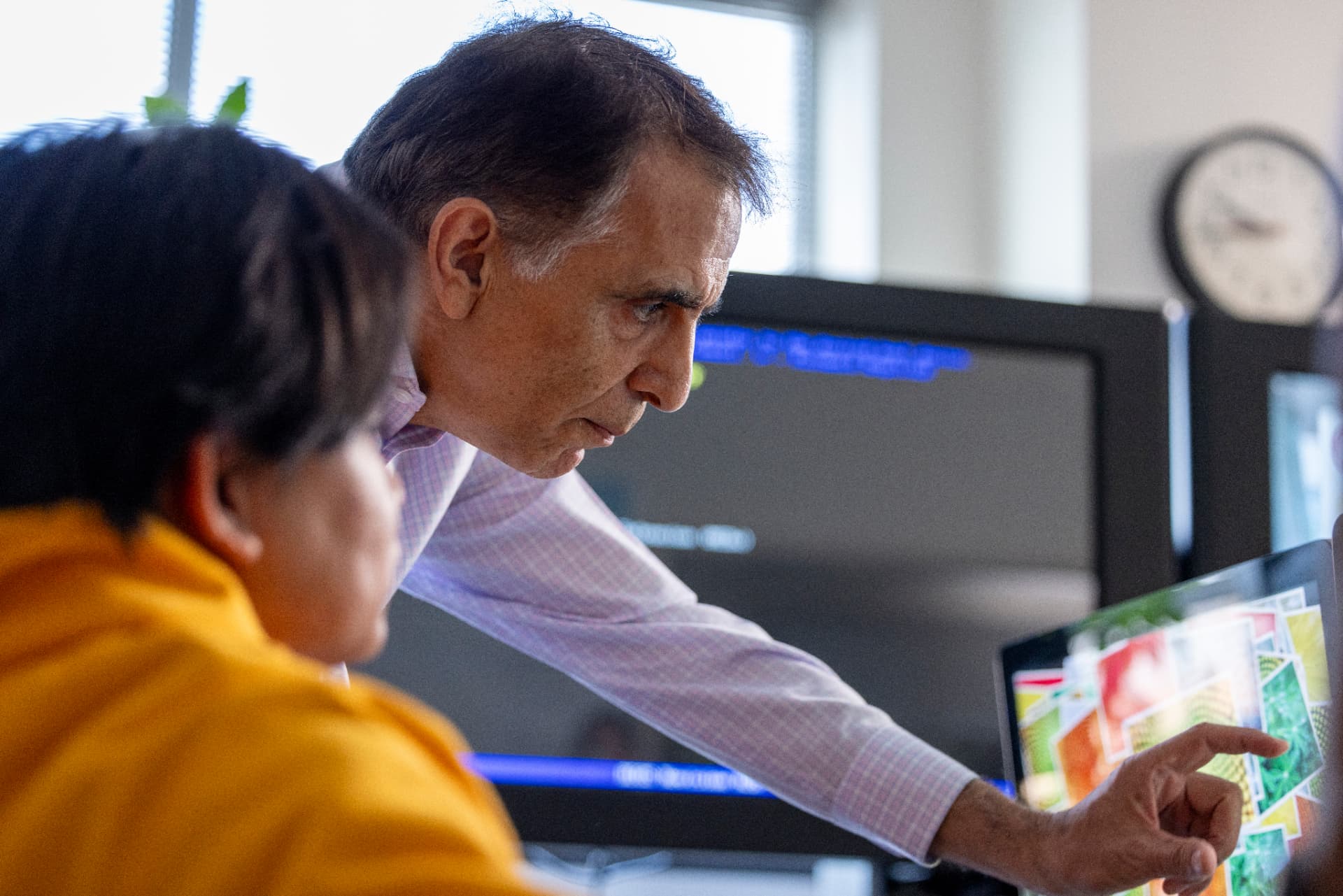 A Bowie State faculty mentor reviewing work on screen with a student